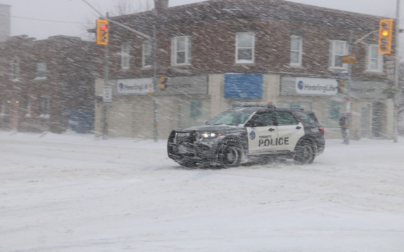 A Toronto Police vehicle in a snowstorm at Danforth and Coxwell